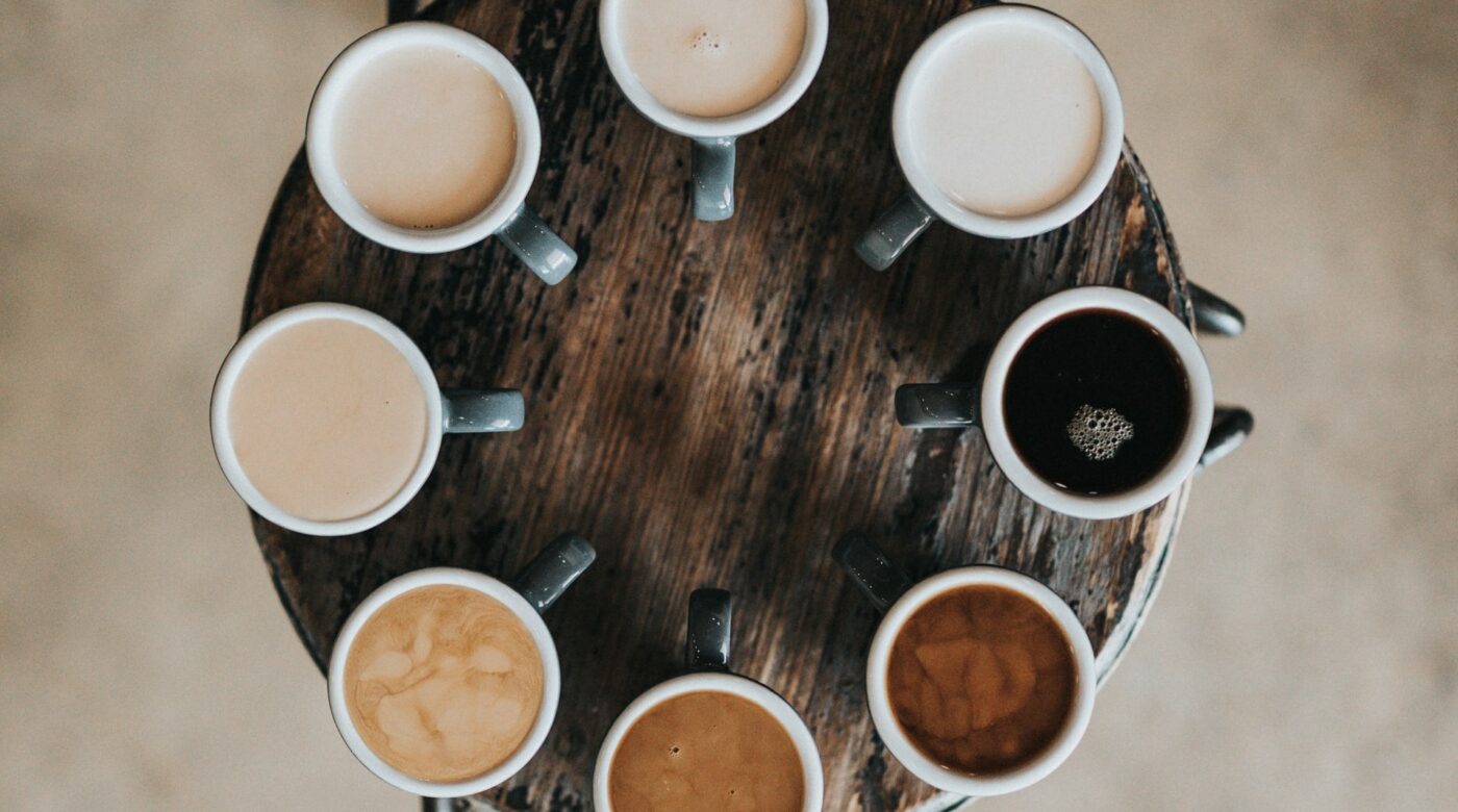 Circle of coffee cups; each with a different appearance - white to black