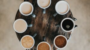 Circle of coffee cups; each with a different appearance - white to black